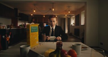 School boy sat in kitchen eating cereal